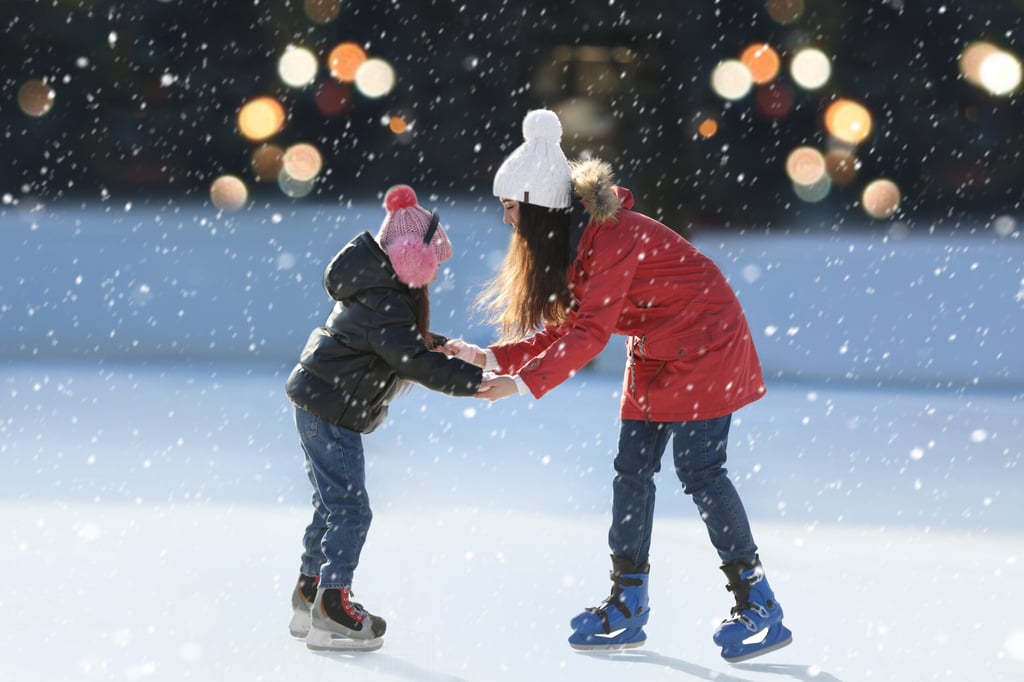 Una madre y su hija pasan tiempo juntas en una pista de patinaje sobre hielo al aire libre
